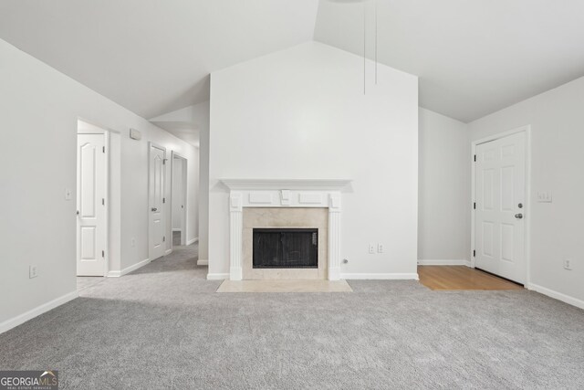 unfurnished living room featuring light carpet and vaulted ceiling