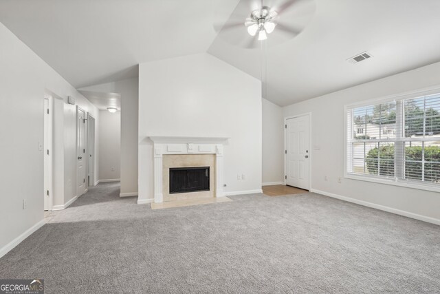 unfurnished living room with light colored carpet, vaulted ceiling, and ceiling fan