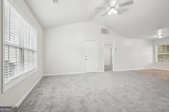 carpeted empty room featuring vaulted ceiling and ceiling fan