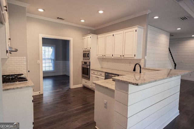 kitchen with white cabinets, dark hardwood / wood-style floors, light stone countertops, and appliances with stainless steel finishes