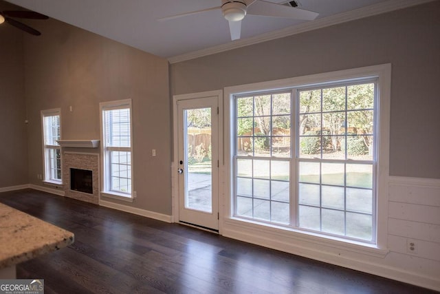 entryway with a fireplace, dark hardwood / wood-style floors, ceiling fan, and crown molding