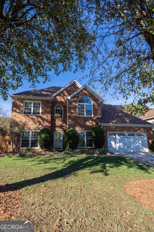 view of property with a garage and a front lawn