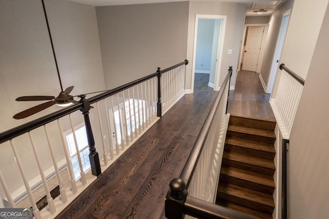 stairs featuring hardwood / wood-style floors and ceiling fan