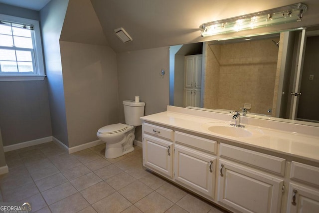 bathroom with tile patterned flooring, vanity, toilet, and tiled shower