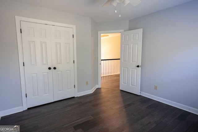 unfurnished bedroom with ceiling fan, dark wood-type flooring, and a closet