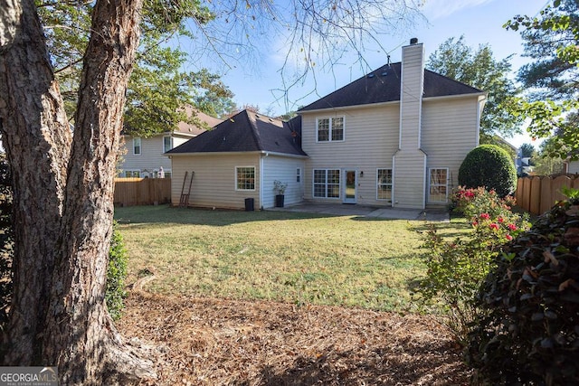 back of property with a lawn and a patio