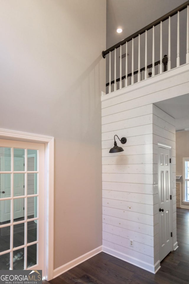 interior details featuring hardwood / wood-style flooring and wooden walls