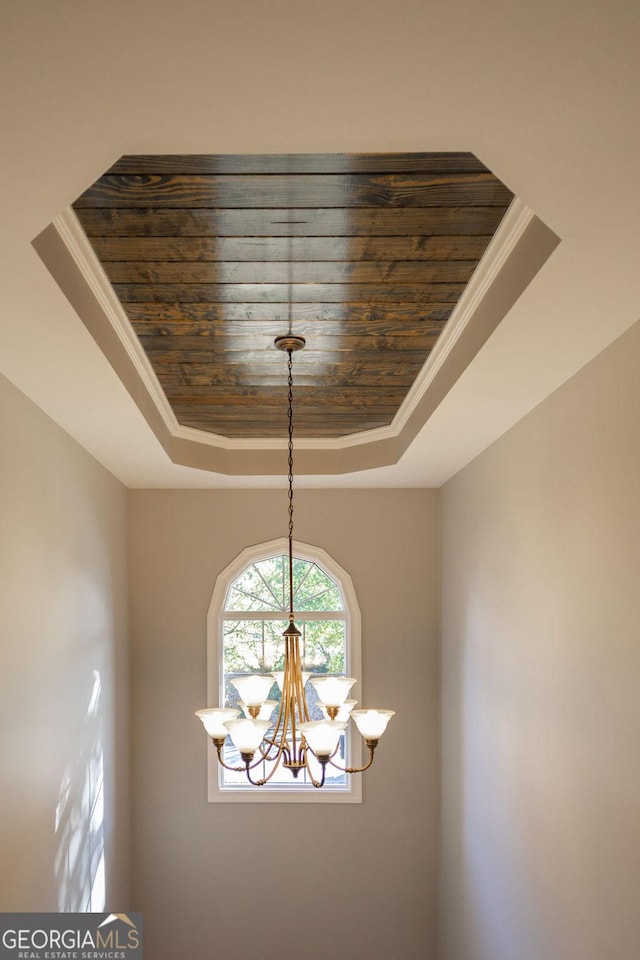 room details featuring a chandelier, a raised ceiling, and wooden ceiling