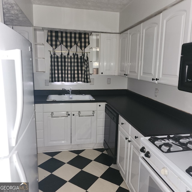 kitchen with stainless steel fridge, white cabinetry, sink, and black dishwasher