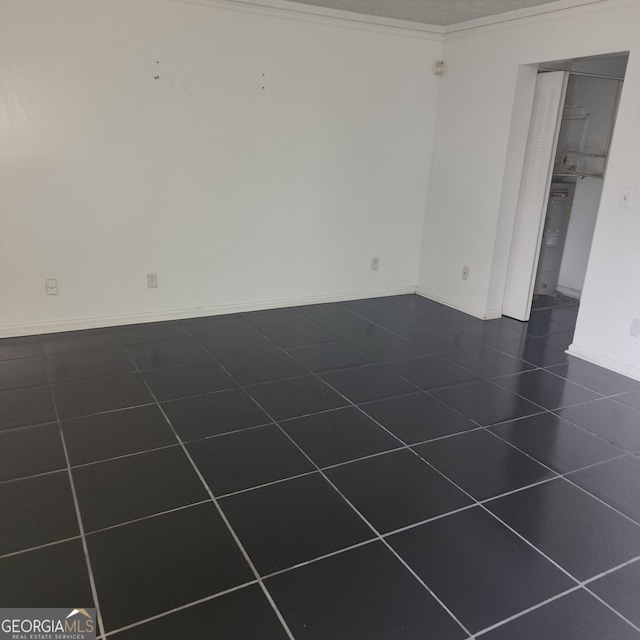 tiled spare room featuring ornamental molding