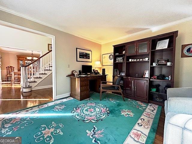 office area with crown molding, an inviting chandelier, a textured ceiling, wood finished floors, and baseboards