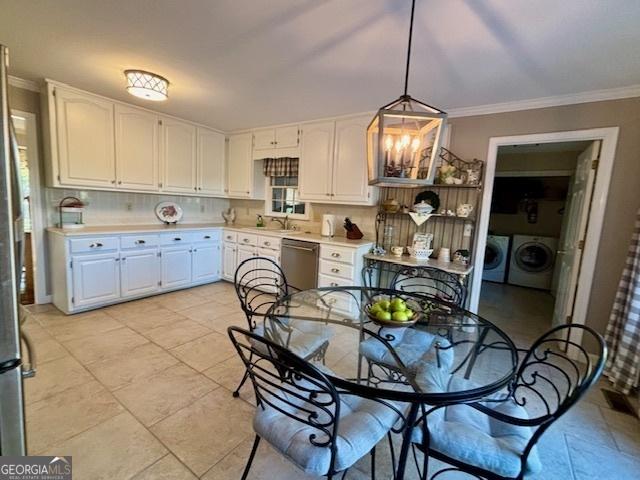 kitchen with separate washer and dryer, white cabinets, light countertops, stainless steel dishwasher, and crown molding