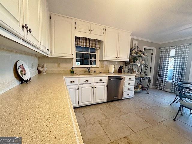 kitchen with tasteful backsplash, dishwasher, light countertops, white cabinetry, and a sink