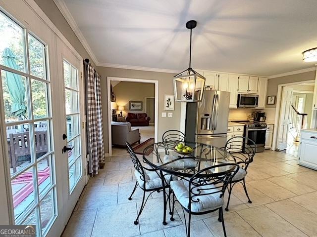 dining space with french doors, stairway, and crown molding