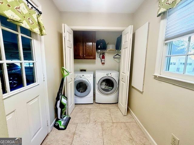 laundry area featuring cabinet space, washer and clothes dryer, and baseboards