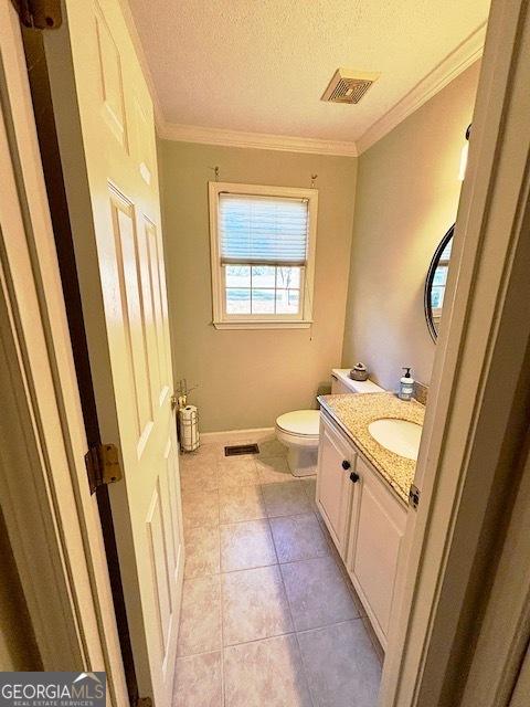 bathroom with toilet, ornamental molding, visible vents, and tile patterned floors