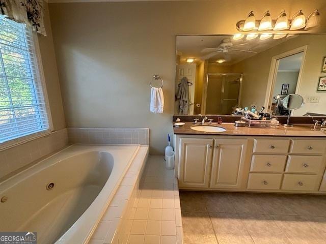 bathroom with double vanity, a stall shower, a sink, tile patterned flooring, and a jetted tub