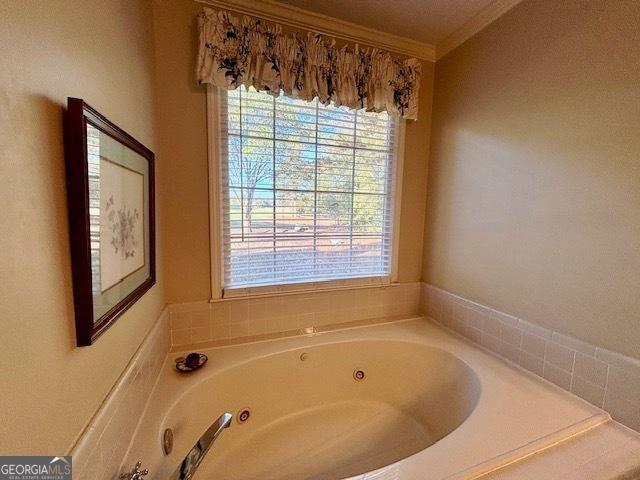 bathroom featuring a tub with jets and ornamental molding