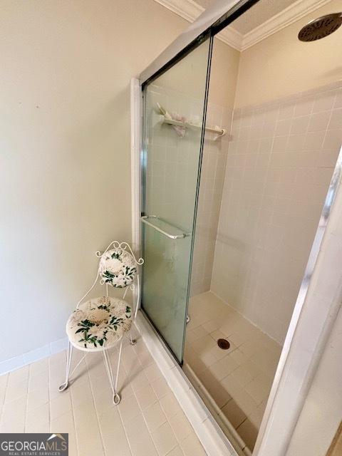 full bath featuring a stall shower, crown molding, and baseboards