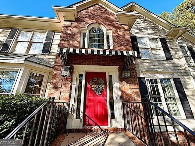 doorway to property featuring brick siding