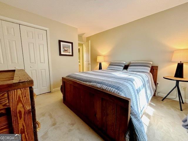 bedroom with a closet and light carpet