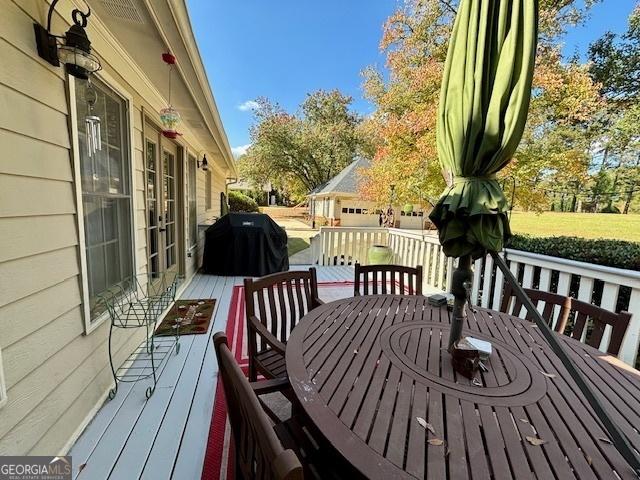 deck featuring outdoor dining space and area for grilling