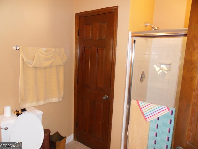 bathroom with toilet and an enclosed shower