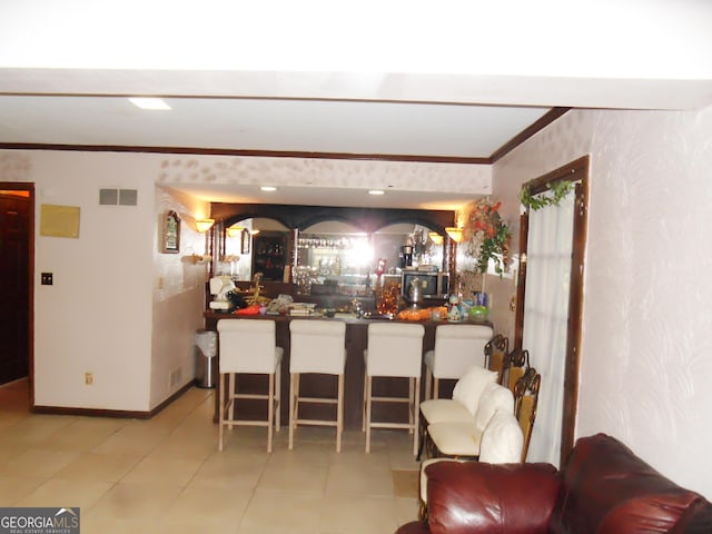 bar with ornamental molding and light tile patterned flooring