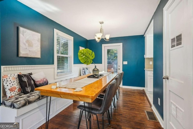 dining room with dark hardwood / wood-style flooring and a notable chandelier