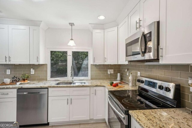 kitchen with white cabinets, decorative light fixtures, and appliances with stainless steel finishes