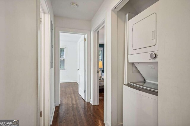 laundry area featuring dark hardwood / wood-style flooring and stacked washer / dryer