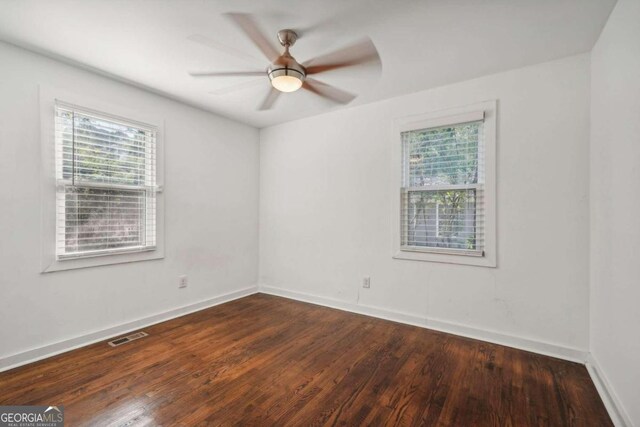 spare room featuring ceiling fan and dark wood-type flooring