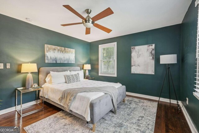 bedroom with dark hardwood / wood-style flooring and ceiling fan