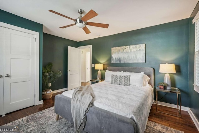 bedroom with a closet, dark hardwood / wood-style floors, and ceiling fan