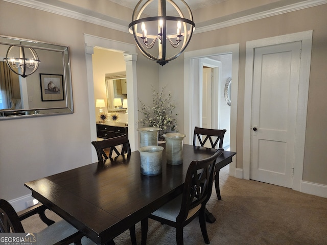 carpeted dining room with ornate columns, ornamental molding, and an inviting chandelier