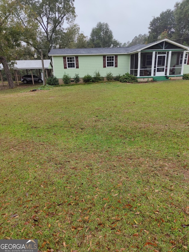 exterior space featuring a carport, a lawn, and a sunroom