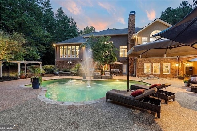 pool at dusk featuring a patio and a pergola