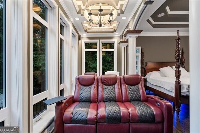 bedroom featuring a raised ceiling, a notable chandelier, crown molding, and ornate columns