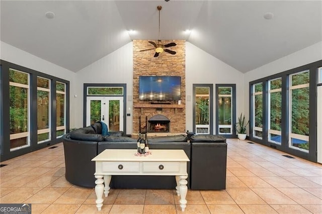 tiled living room with ceiling fan, french doors, a fireplace, and high vaulted ceiling