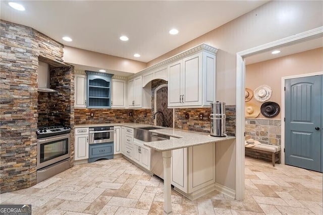 kitchen with white cabinetry, stainless steel appliances, sink, backsplash, and kitchen peninsula