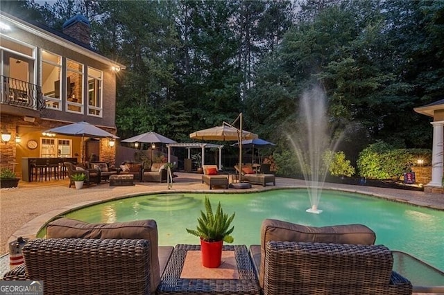 view of pool with pool water feature, an outdoor hangout area, exterior bar, and a patio area