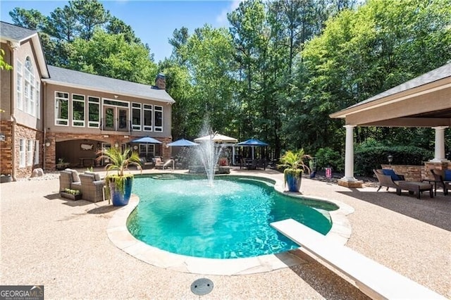 view of pool featuring pool water feature, a gazebo, a diving board, and a patio area