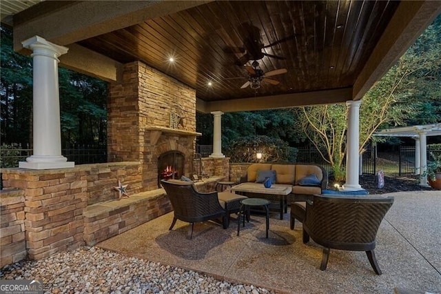 view of patio / terrace featuring ceiling fan and an outdoor living space with a fireplace