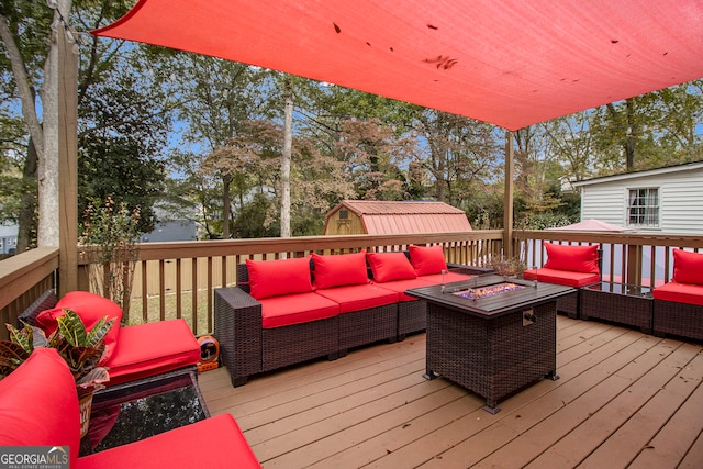 wooden terrace with a storage unit and an outdoor living space with a fire pit