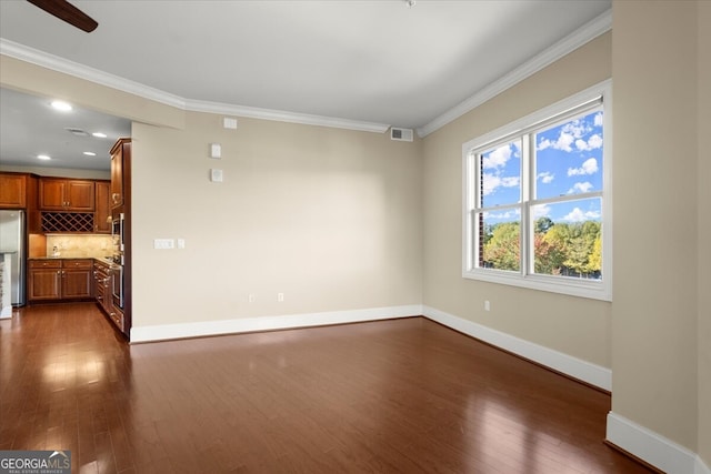 unfurnished living room with ceiling fan, crown molding, and dark wood-type flooring