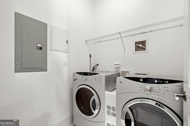 clothes washing area with electric panel and washing machine and dryer