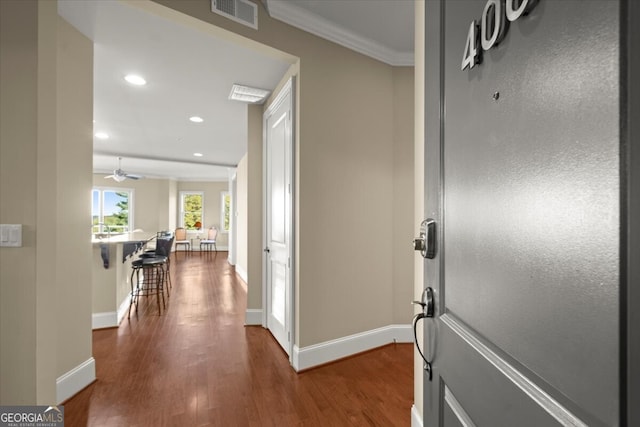 entrance foyer with wood-type flooring, ceiling fan, and ornamental molding