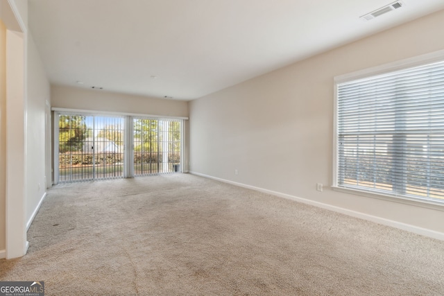 unfurnished room featuring a wealth of natural light and carpet floors