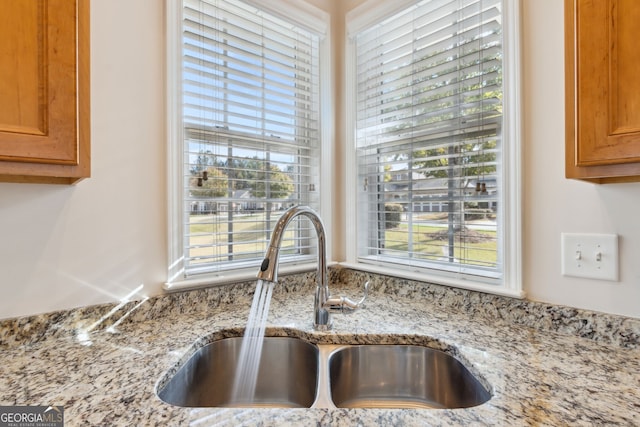 room details featuring light stone counters and sink