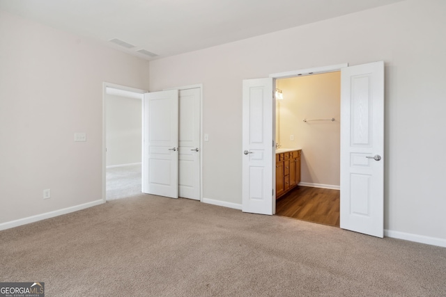 unfurnished bedroom featuring carpet flooring and ensuite bath